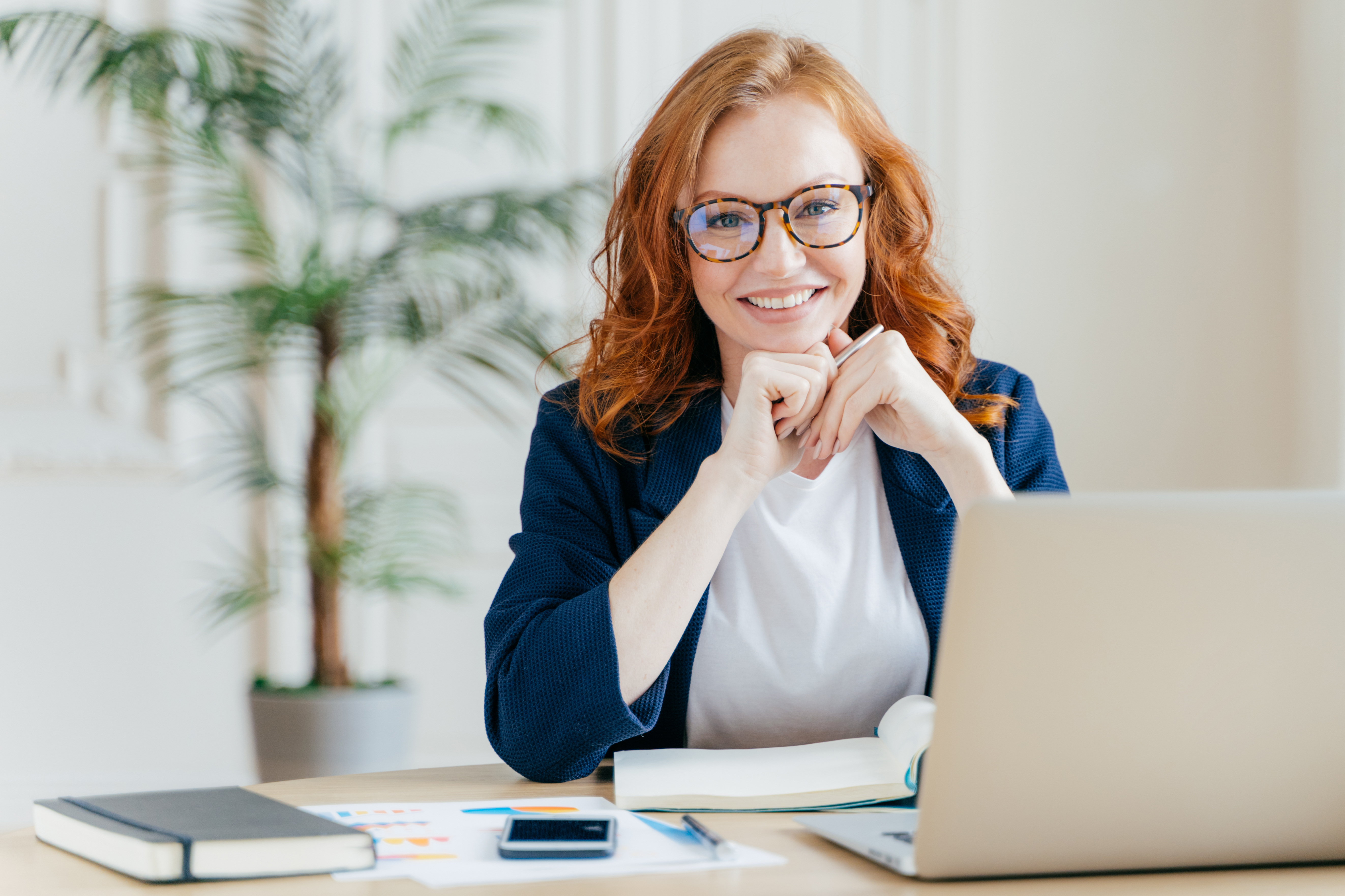 Woman Smiling Behind Laptop