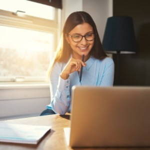 Woman smiling in front of her laptop